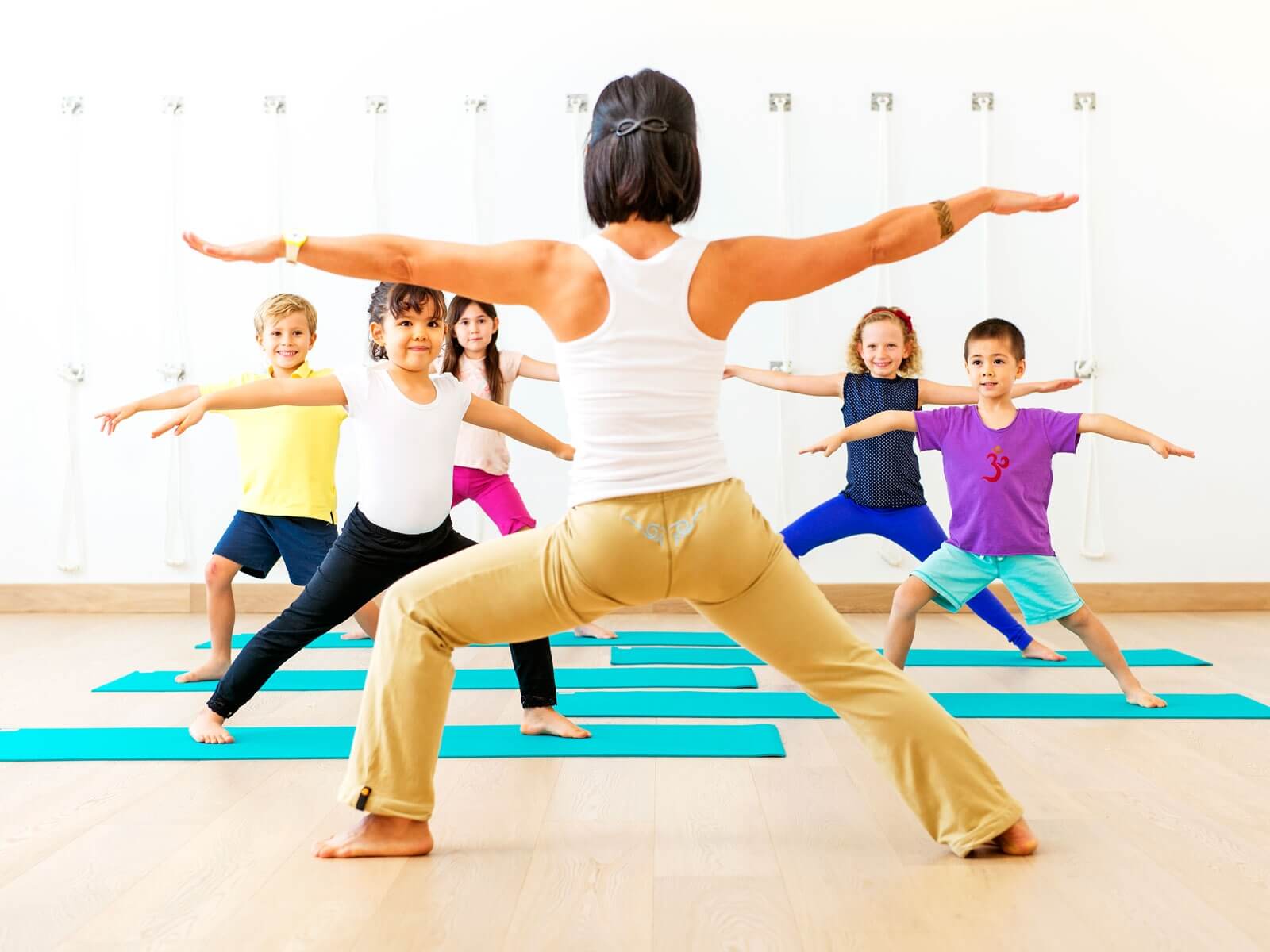 A yoga teacher teaching yoga to the kids