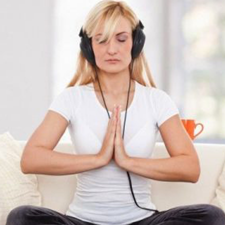 A woman listening with headphones while meditating